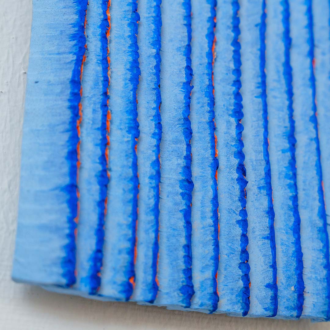 Foto van een kunstwerk aan de muur in blauw met overlappende vlakken 