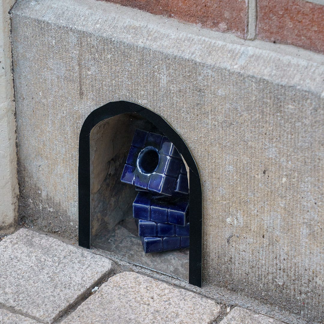 Foto van schoenschraper met een kunstwerkje erin